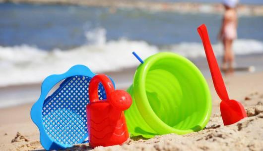 Giochi da spiaggia sulla sabbia con mare sullo sfondo.